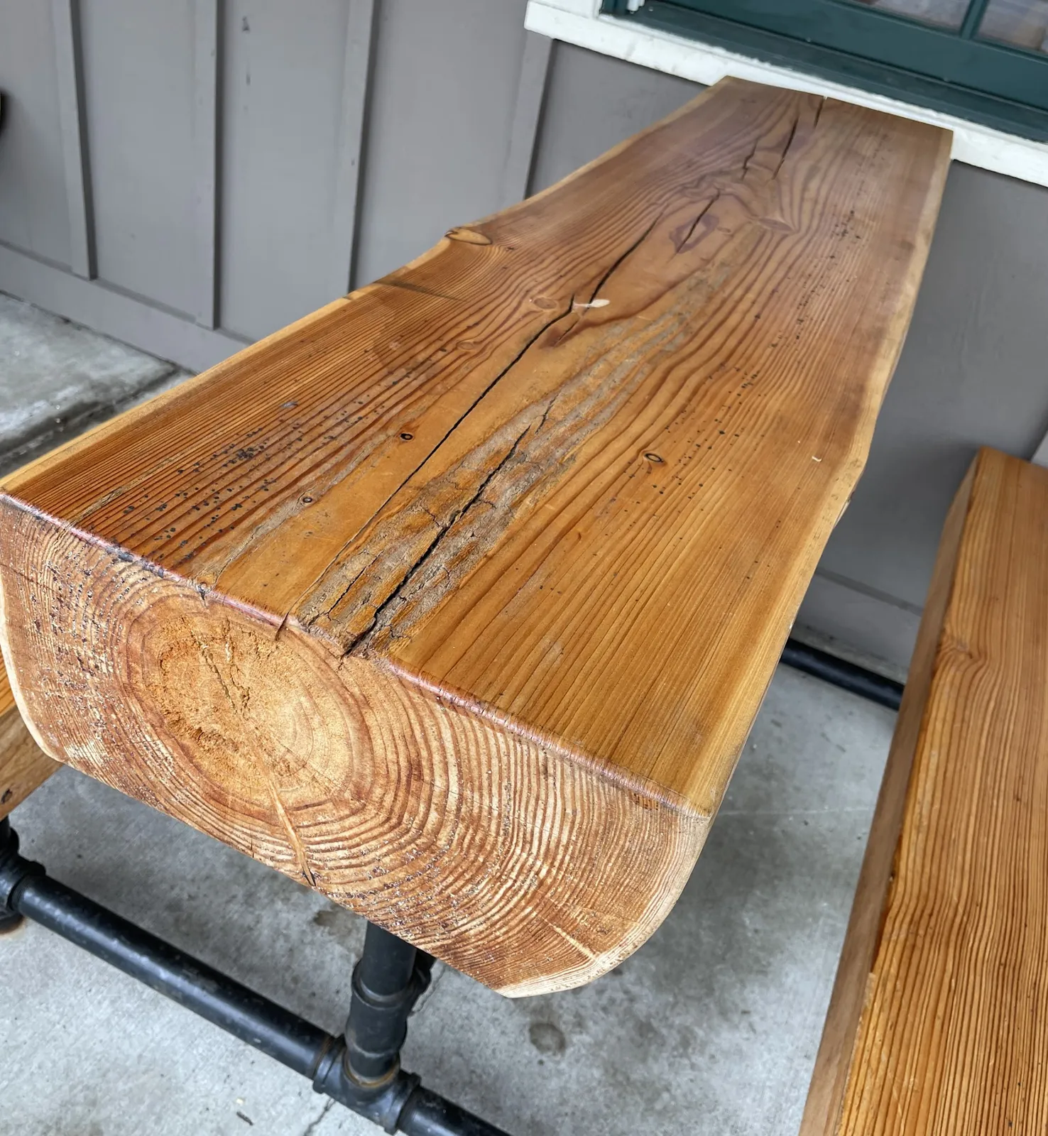 Weathered log table with cracks before restoration