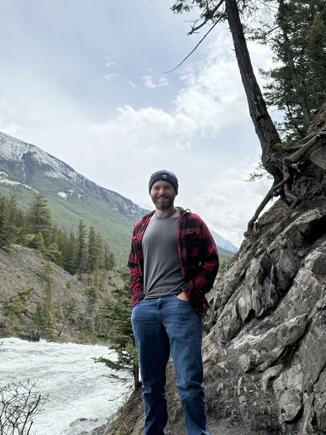 Cameron Sexsmith standing on a rocky trail above a mountain river