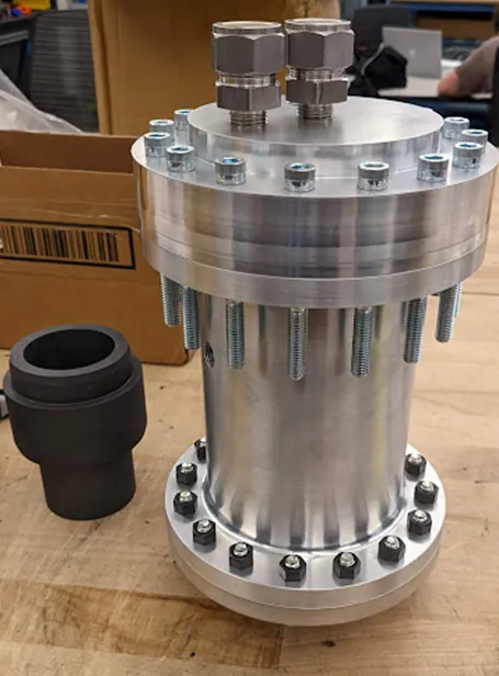 Machined Project Juno engine hardware on a workbench
